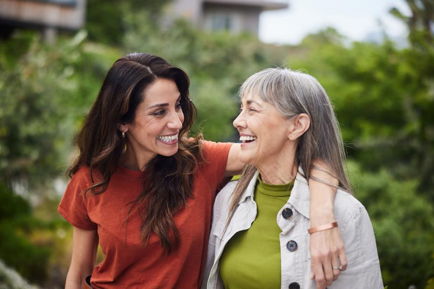 Mother and adult daughter walking outside