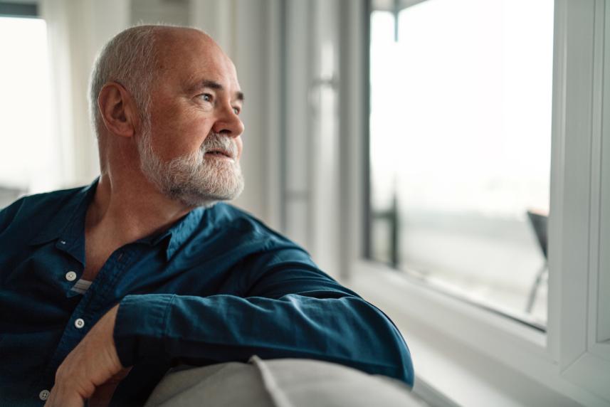 A man looks pensively out the window.