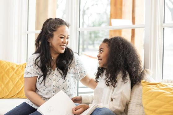 Mother and daughter sitting together on a couch