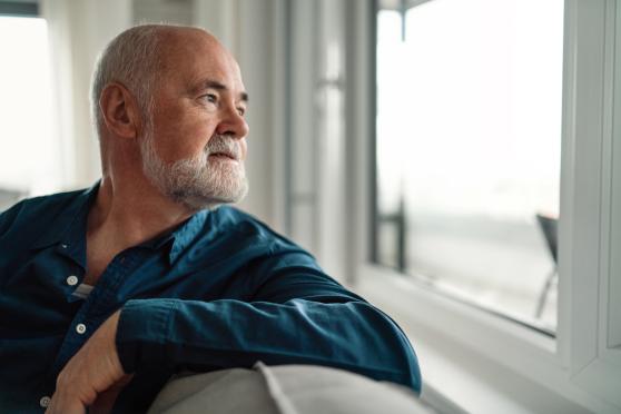 A man looks pensively out the window.